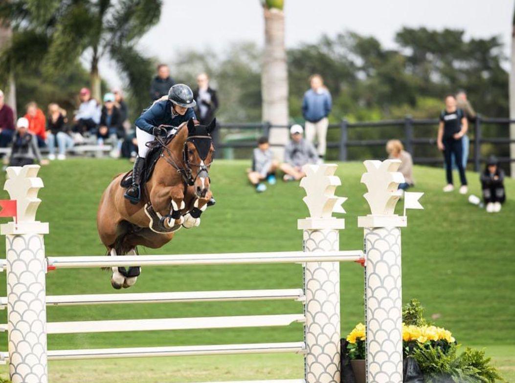 Ashlee and her horse over white rails